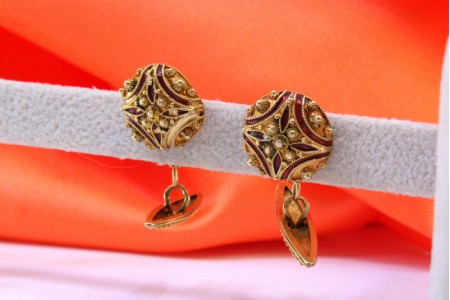 Botões de punho em ouro com rosinhas e decoração esmaltada.